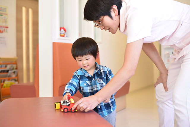 お子さんとおもちゃで楽しく遊ぶスタッフ